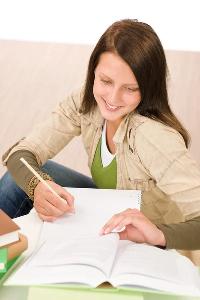 Studente adolescente ragazza scrivere compiti con libro — Foto Stock