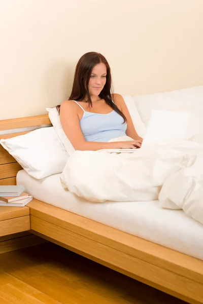 Beautiful woman working on computer in bed — Stock Photo, Image