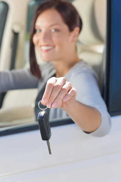 Attractive businesswoman in new car showing keys — Stock Photo, Image