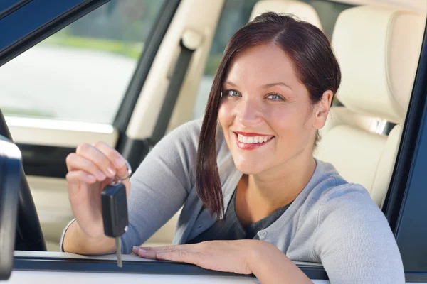 Empresária atraente em carro novo mostrando chaves — Fotografia de Stock