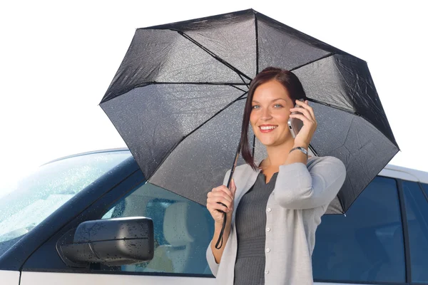 Empresária sob guarda-chuva por carro de luxo chamando — Fotografia de Stock