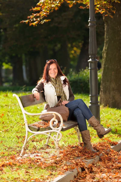 Autunno bella donna sedersi su panchina parco — Foto Stock
