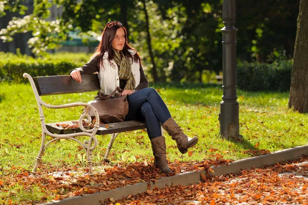 Φθινόπωρο όμορφη γυναίκα να καθίσει στον πάγκο πάρκο — Φωτογραφία Αρχείου