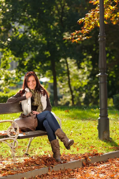 Ősz gyönyörű nő ül a padon park — Stock Fotó