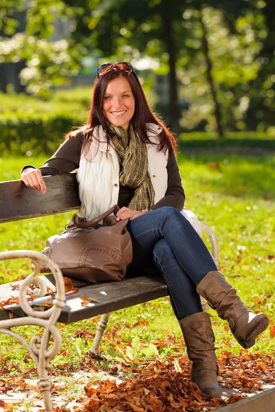 Outono bela mulher sentar-se no parque de banco — Fotografia de Stock