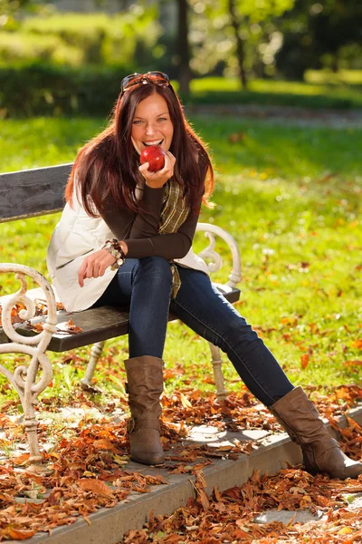 Herfst aantrekkelijke vrouw eten apple sunset park — Stockfoto