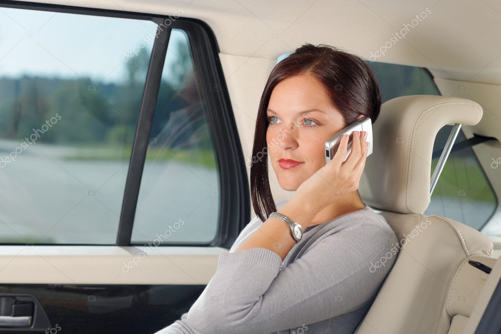 Executive iş kadını sit arabanın arka koltukta arama Stok