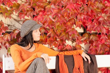 Autumn fashion young woman relax on bench clipart