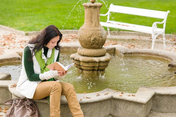 Autumn park fountain young woman read book — Stock Photo, Image