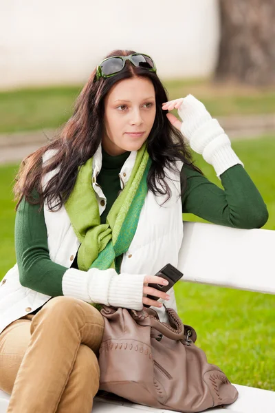 Jesień kobieta młody park ława trzymaj telefon — Zdjęcie stockowe
