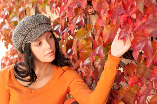 Herbstliche Parkbank junge Frau berührt Blatt — Stockfoto