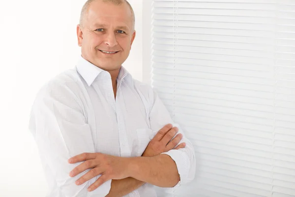 Reifer Geschäftsmann lächelt verschränkte Arme posierend — Stockfoto