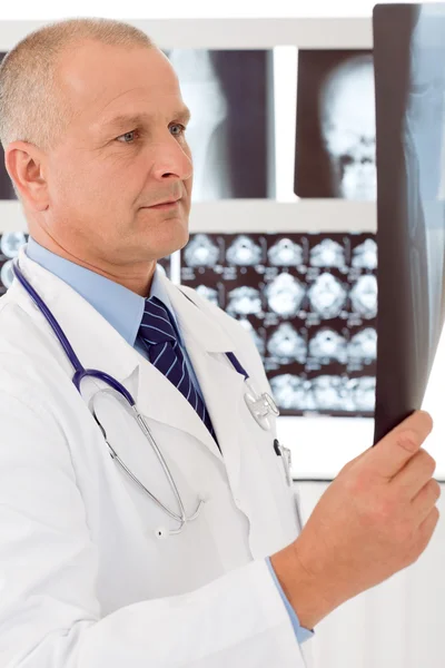 Зрілий старший лікар чоловік виглядає осторонь рентгенівського — стокове фото