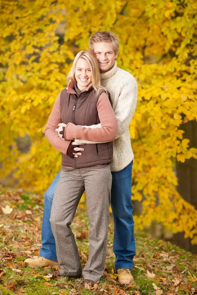 Hösten älskar par kramar glad i park — Stockfoto