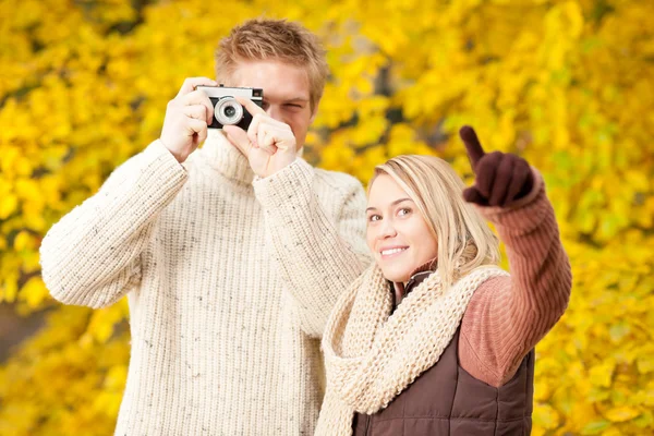 Autumn couple take photo camera in park — Stock Photo, Image