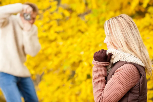 Осенний мужчина фотографирует молодую женщину — стоковое фото