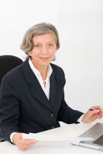 Senior mujer de negocios sonrisa sentarse detrás de escritorio de oficina — Foto de Stock