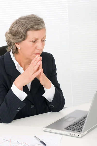 Senior businesswoman look seriously at computer — Stock Photo, Image