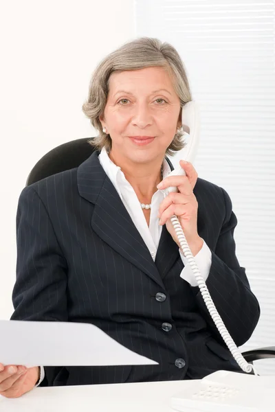 Senior zakenvrouw op telefoon bezit leeg vel — Stockfoto