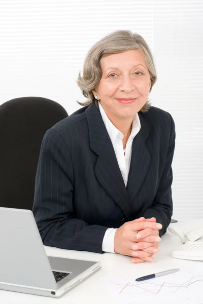 Senior businesswoman sit behind office desk — Stock Photo, Image