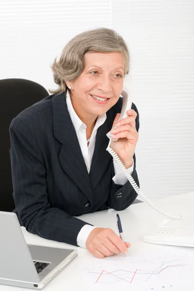 Senior mujer de negocios sonrisa sentarse detrás de escritorio de oficina — Foto de Stock