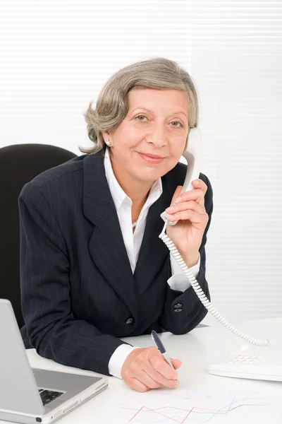 Senior üzletasszony mosoly ül íróasztal mögött — Stock Fotó