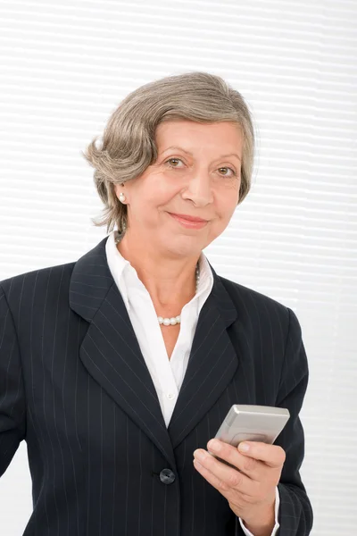Старша бізнес-леді посмішка тримає мобільний телефон — стокове фото