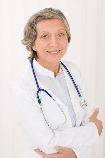 Médico senior mujer con estetoscopio sonriendo — Foto de Stock