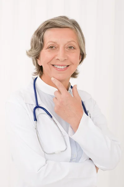 Старшая врач женщина со стетоскопом улыбается — стоковое фото
