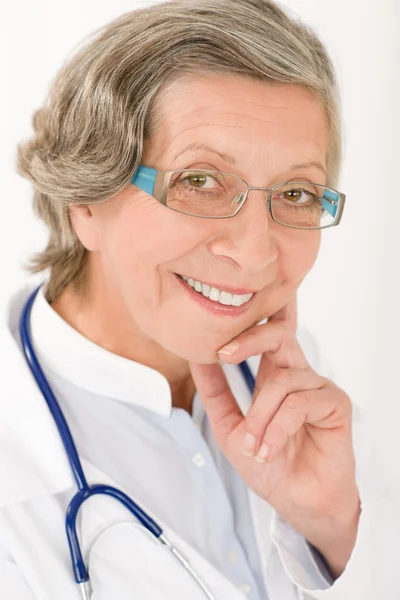 Médico senior mujer con estetoscopio sonriendo — Foto de Stock