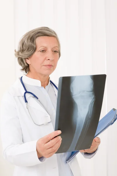 Старший лікар жінка дивиться на рентгенівський знімок — стокове фото
