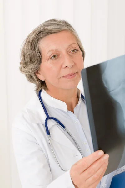 Médico senior mujer mirando rayos X —  Fotos de Stock