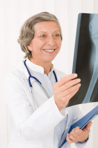 Médico sênior fêmea sorrindo segurar raio-x — Fotografia de Stock