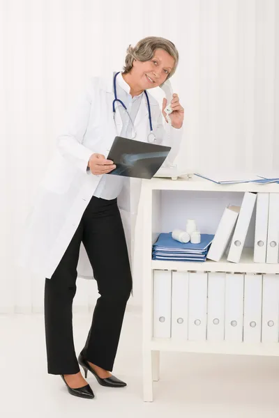 Medico anziano donna tenere i raggi X e telefono — Foto Stock