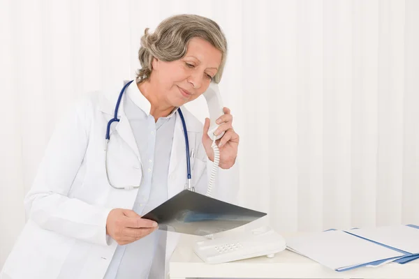 Överläkare kvinna håller röntgen och telefon高级医生女性举行 x 射线和电话 — 图库照片