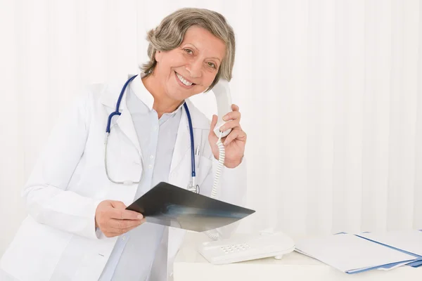 Médico senior mujer mantenga rayos X y teléfono —  Fotos de Stock