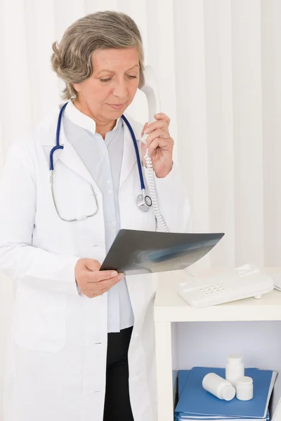 Médico senior mujer mantenga rayos X y teléfono —  Fotos de Stock