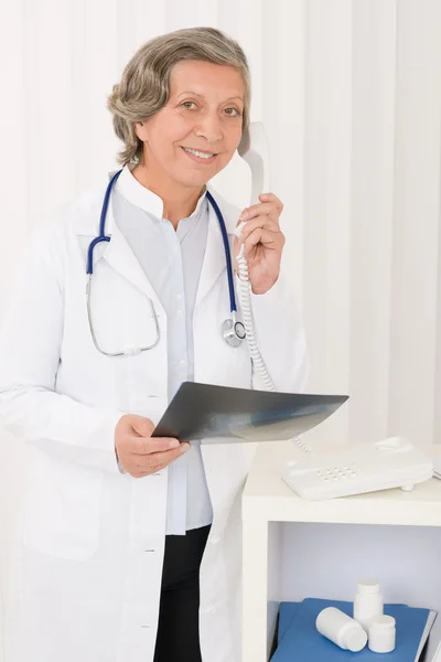 Starszy lekarz kobieta trzymać telefon i x-ray — Zdjęcie stockowe