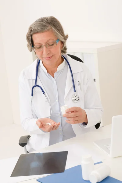 Medico medico senior femminile tenere pillole ufficio — Foto Stock