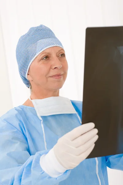 Старшая женщина-хирург проводит рентгеновскую защиту — стоковое фото