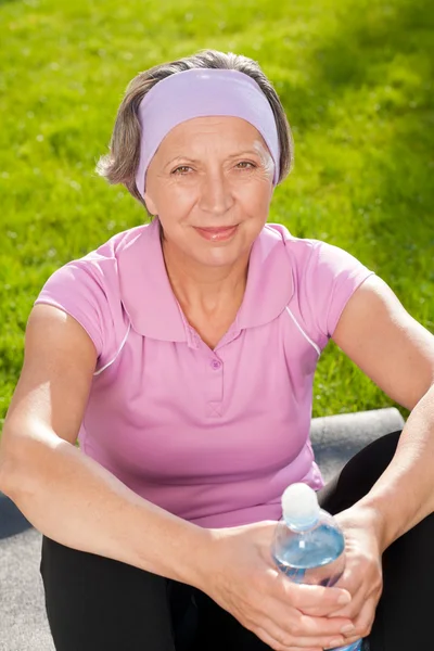 Старшая спортивная женщина счастливо держать бутылку воды — стоковое фото