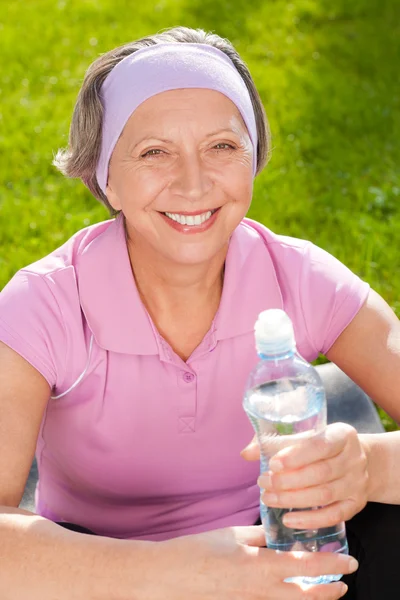 Senior sportive femme sourire tenir bouteille d'eau — Photo