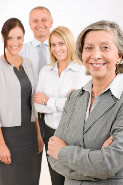 Affärskvinna senior med kollegor i ryggen — Stockfoto