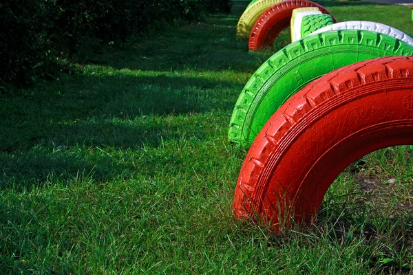 Painted wheels from rubber fixed at playground — Stock Photo, Image
