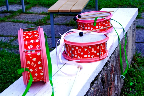 Tamburi decorati rosa che posano su panchina bianca — Foto Stock