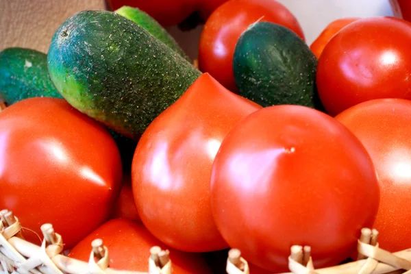 Foto of cucumber and tomatoes laying nearby — Stock Photo, Image