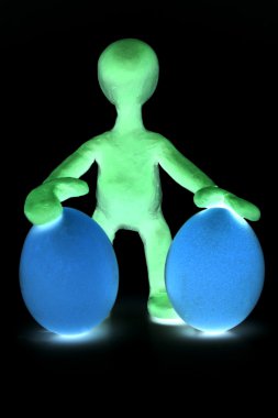 Shaded puppet of plasticine holding two eggs clipart