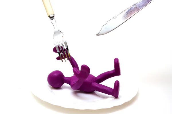Purple puppet of plasticine laiyng under threat — Stock Photo, Image