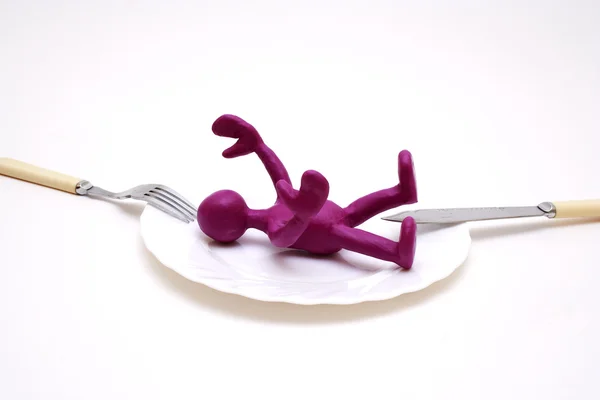 Purple puppet of plasticine laying between threat — Stock Photo, Image