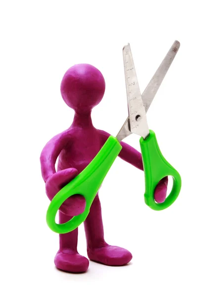 Purple puppet of plasticine holding green scissors — Stock Photo, Image